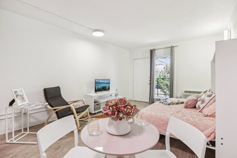 a living room with a bed and a table and chairs